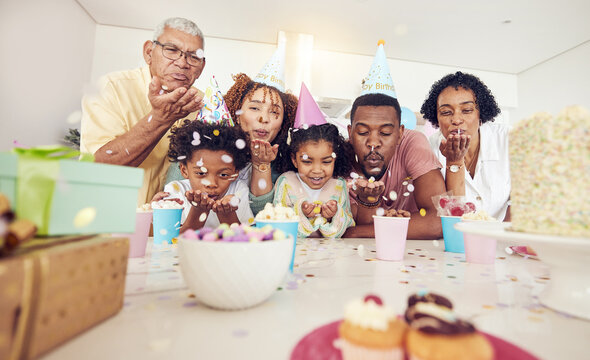 Birthday, party and confetti with family in kitchen for celebration, bonding and affectionate. Happiness, excited and grandparents with parents and child at home for surprise, fun and event