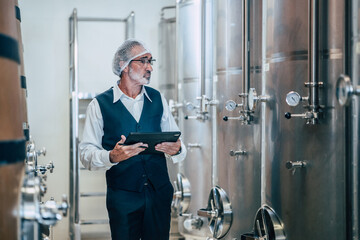 Winemaker working in modern large winery factory liquor drink industry quality and fermentation monitor