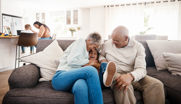 Tickle, laughing and child with grandparents on sofa of living room for bonding, happy family and playful. Tickling, boy and fun with senior people at home for happiness, generations and funny game