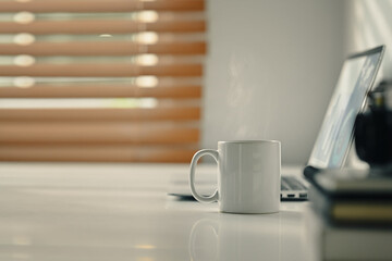 A cup of hot coffee on a white working desk in the morning sun light. Copy space for your text 