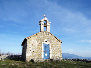 Fototapeta na wymiar Stone chapel on mountain standing above Kotor Bay in Montenegro, Europe