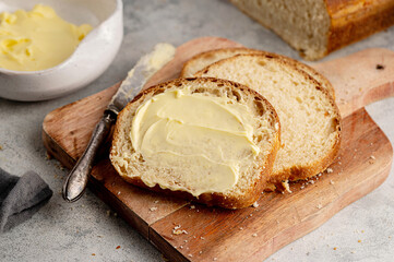 Closeup sourdough slice of homemade white loaf bread with butter. 
