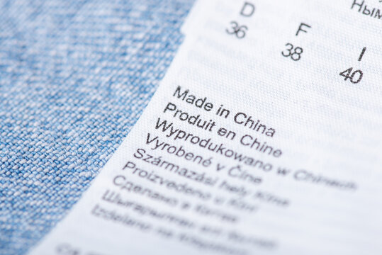 Close up on a label of a shirt with inscription Made in China in different languages. Producing clothes in China and exporting them to different countries