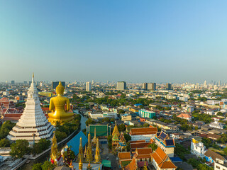 Fototapeta premium .aerial view golden big Buddha Wat Paknam Phasi Charoen in sunset. .beautiful sunset reflection on a canal in front big buddha. .scenery sky in twilight background.the one famous landmarks 