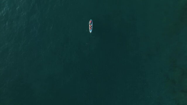 Aerial view of young couple stand up paddling on vacation