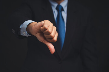 Negative concept. Close-up of businessman's hand showing a thumbs down for dislike service