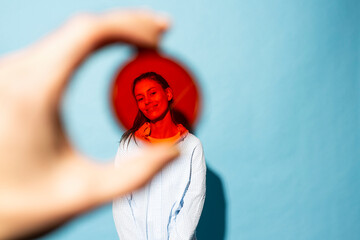 Woman seen through red lens filter against blue background