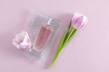 a transparent bottle of spray or women's toilet water lies on a relief glass tray with spring flowers. aroma presentation. mock-up.