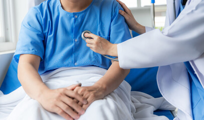 Close up of doctor sitting on bedside of male patient in hospital