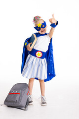 Pre schooler daughte in super hero costume standing on white background holding book and grey backpack ready to school concept.