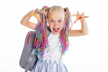 Modern small school girl stands on white background isolated holding backpack looking at camera posing in stylisg clothes laughing back to school concept.