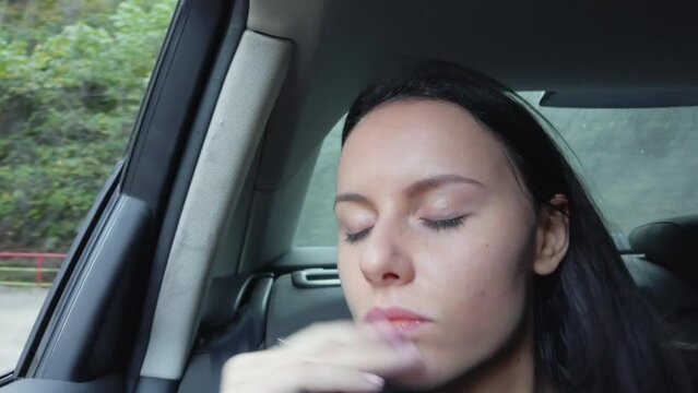 Nervious business young woman in the backseat of a car looking out the window and being anxious