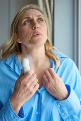 Menopausal Mature Woman Having Hot Flush At Home Cooling Herself With Handheld Electric Fan © highwaystarz