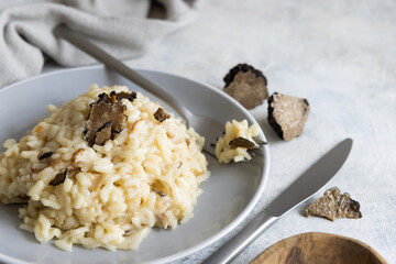 Risotto with porcini mushrooms and black truffles served in a plate top view, gourmet cousine