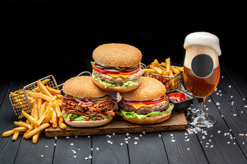 Set of different burgers with french fries and a glass of beer. Burger with chicken, beef and...