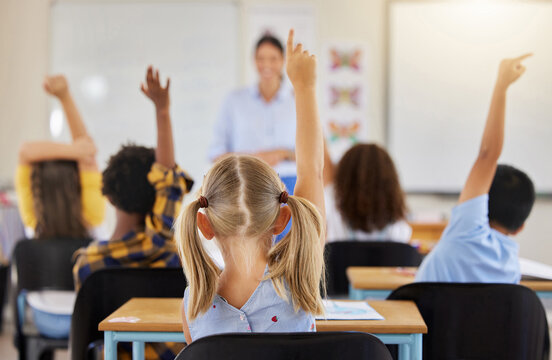 Answering, back and children raising hand in class for a question, answer or vote at school. Teaching, academic and a student asking a teacher questions while learning, volunteering or voting