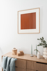 picture, modern vase and candles on wood furniture in bedroom