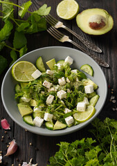 Ketogenic diet green salad with cucumbers, avocado, feta cheese and lime dressing.

