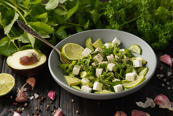 Ketogenic diet green salad with cucumbers, avocado, feta cheese and lime dressing.

