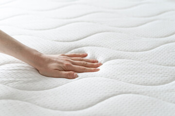 woman press on comfortable mattress and checking quality - obrazy, fototapety, plakaty