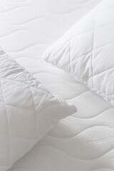 background of soft pillows on white quilted mattress