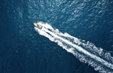 High angle view of a motorboat speeding on the ocean with copy space - 586532395