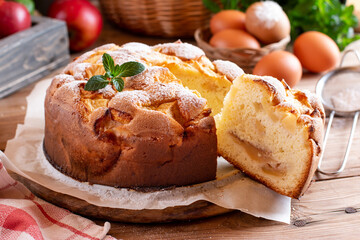 Clasic sponge cake with apples on wood table. Homemade cake