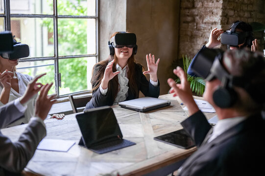 Multiracial business people hi-tech meeting, creative teamwork standing in modern office and using vr headsets, trying new project and gesturing in the air