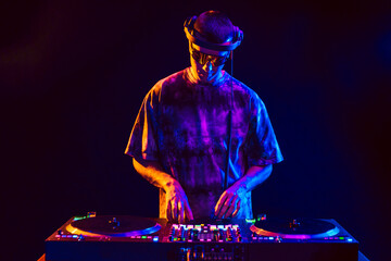 Club DJ playing music at party wearing sunglasses