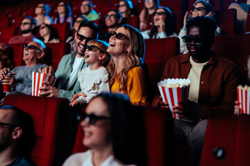 Happy family watching 3D movie in theater.