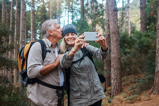 Elderly, couple take selfie and hiking in forest, happy people in nature and memory for social media post. Smile in picture, adventure and fitness, old man and woman are outdoor with active lifestyle