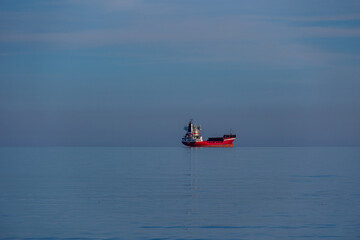 red cargo ship in the blue sea calm minimalist landscape
