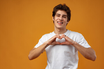 Portrait of happy handsome man making heart with fingers