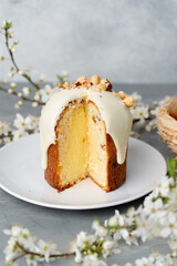 Piece of Easter cake on plate decorated with spring flower branches