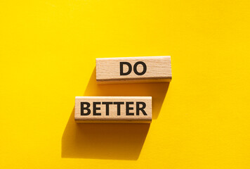 Do better symbol. Wooden blocks with words Do better. Beautiful yellow background. Business and Do better concept. Copy space.