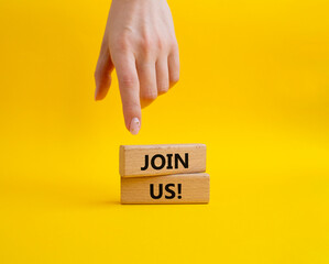 Join us symbol. Concept word Join us on wooden blocks. Beautiful yellow background. Businessman hand. Business and Join us concept. Copy space