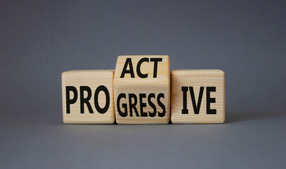 Proactive and Progressive symbol. Turned wooden cubes with words Progressive and Proactive. Beautiful grey background. Business concept. Copy space