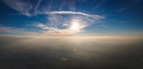 Aerial view from airplane window at high altitude of earth covered with white thin layer of misty...