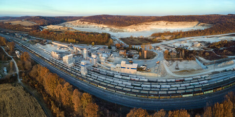 Aerial view of cargo train loaded with crushed sandstone materials at mine factory. Railway transportation of open pit mining ore