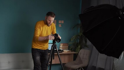 Photographer shooting cosmetic product in photography home studio with lighting equipment
