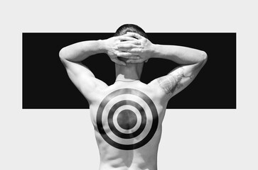 Man with a target drawn on his back holds his hands on the back of his head