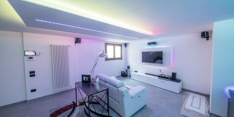 Modern room with bight led strips light. Tv, monitor and sofa