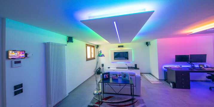 Moving to a new house. House interior. Ideas for basement living room. Entertainment room with TV and color led strips