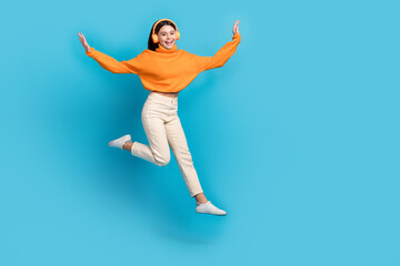 Fototapeta na wymiar Full length photo of crazy cheerful person jumping enjoy music empty space isolated on blue color background