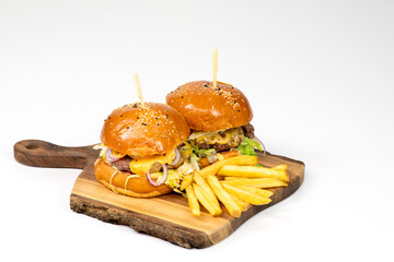 Two fresh homemade hamburgers on wooden serving board with fries. White background with copy space