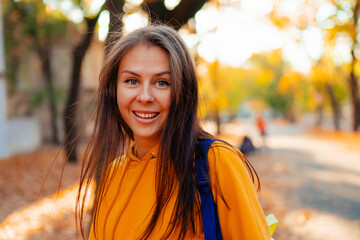 Portrait of a happy smiling young woman while walking outdoors.