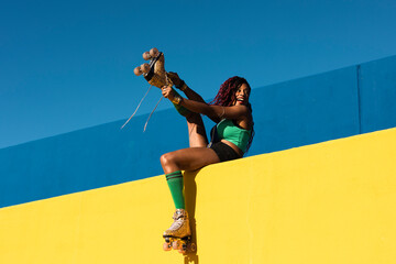 Urban woman enjoy outside. Modern woman posing with roller skates.