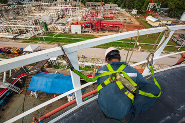 Male worker wearing safety first harness and safety lone working at high handrail