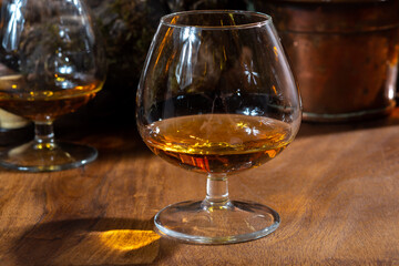 Tasting of aged french cognac brandy alcoholic drink in old cellars of cognac-producing regions Champagne or Bois, France