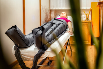 Pressotherapy procedure with overalls in a beauty salon. Modern lymphatic drainage massage. Health and beauty concept
